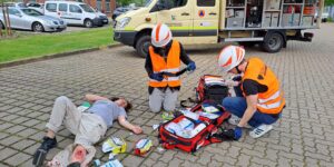 Zwei Sanitäter versorgen Verletzte mit Wunde am Bein